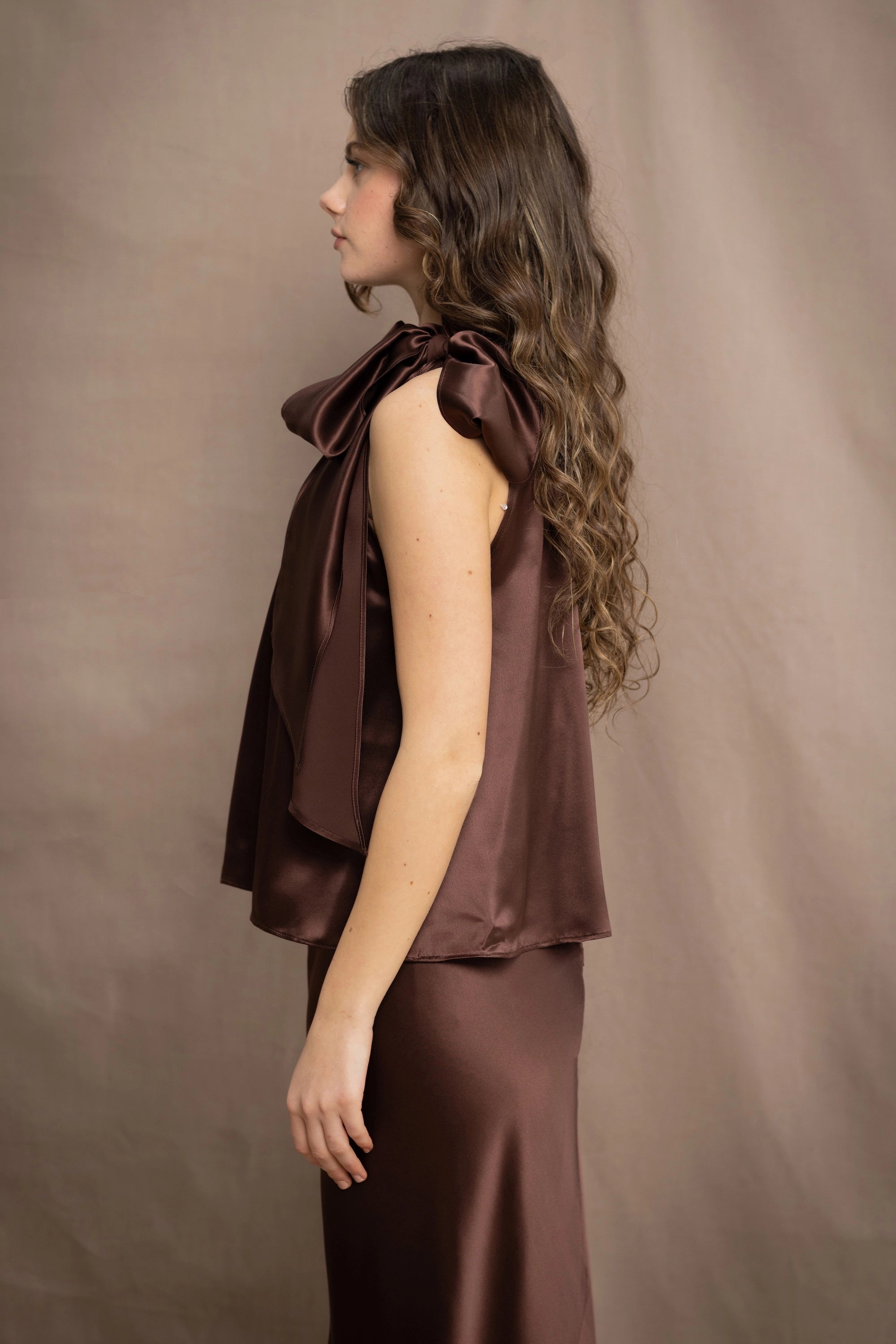 a woman wears a pure 100% silk halter top in chocolate brown with matching silk skirt