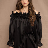a woman wears a black silk ruffle blouse handmade in Ireland