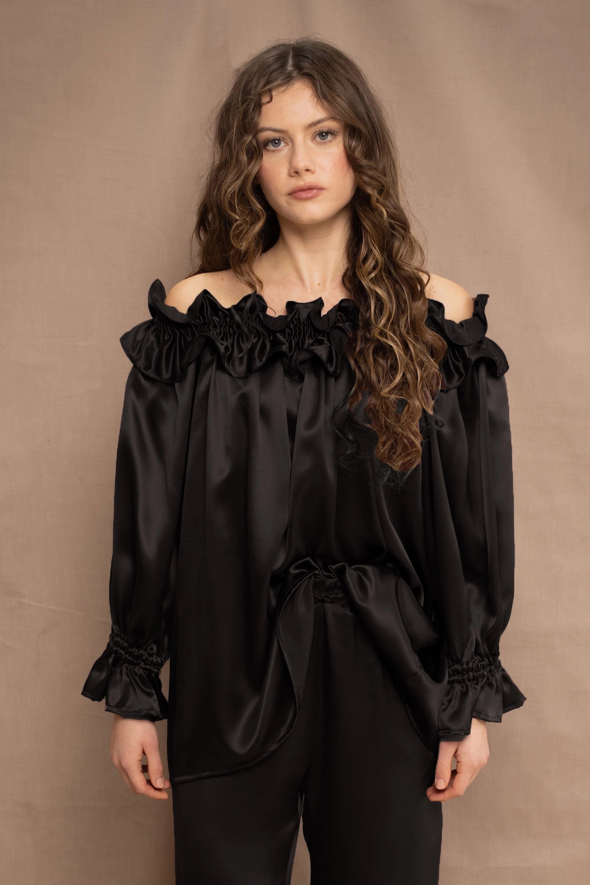 a woman wears a black silk ruffle blouse handmade in Ireland