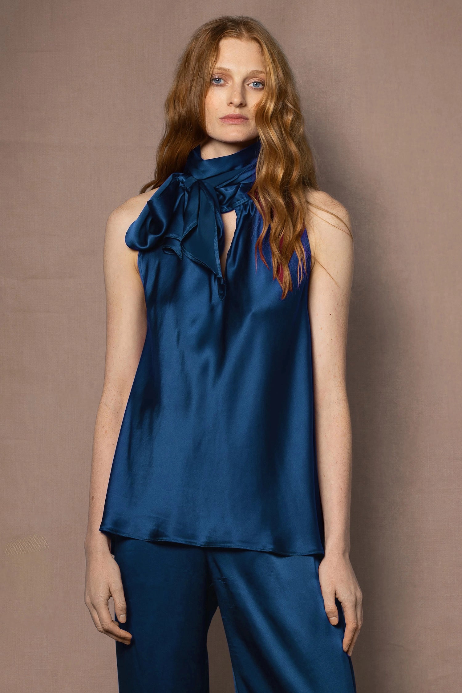 woman wearing sleeveless teal blue top and trousers in silk