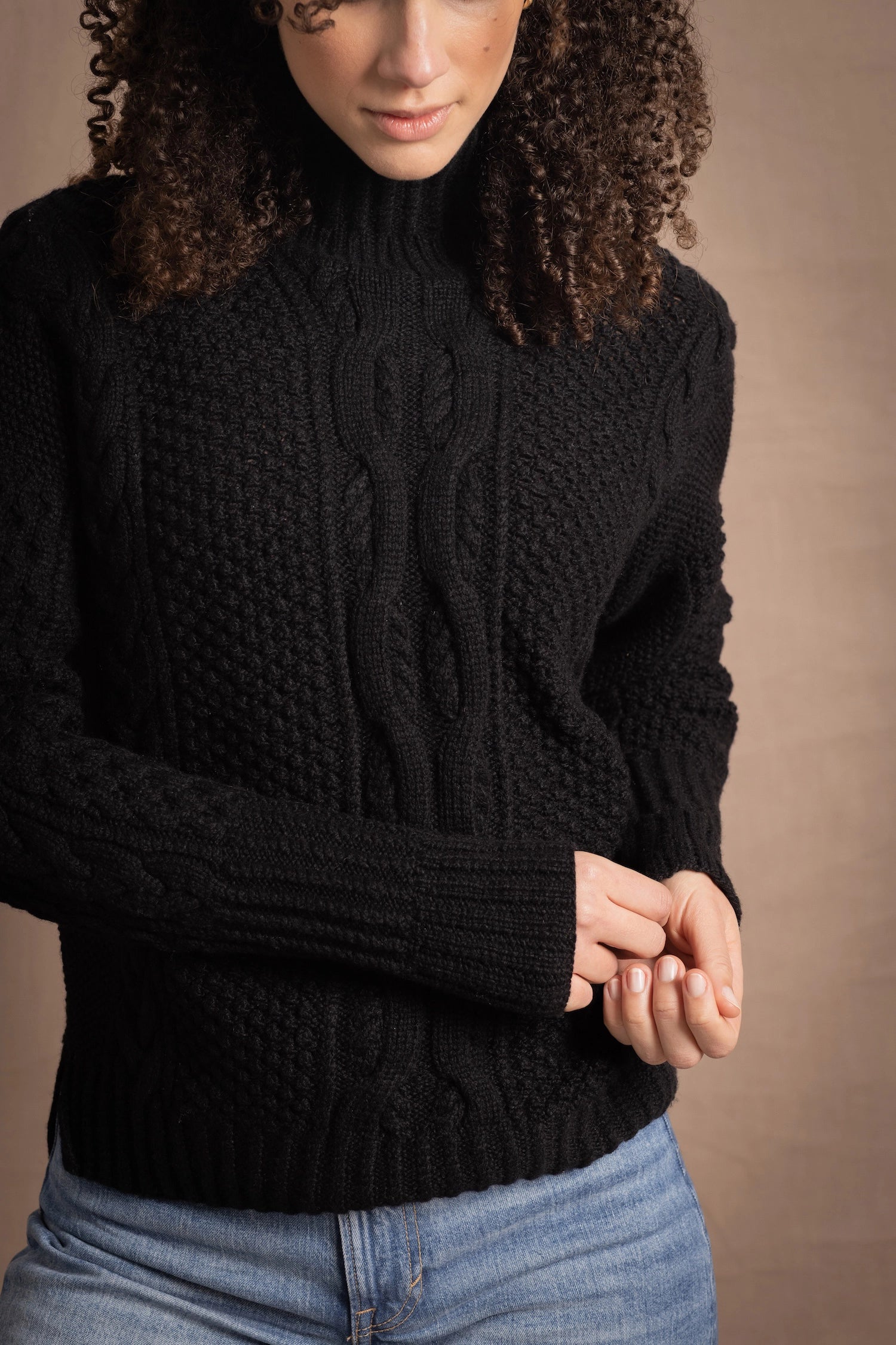 Woman wears traditional Irish Aran Sweater in Black