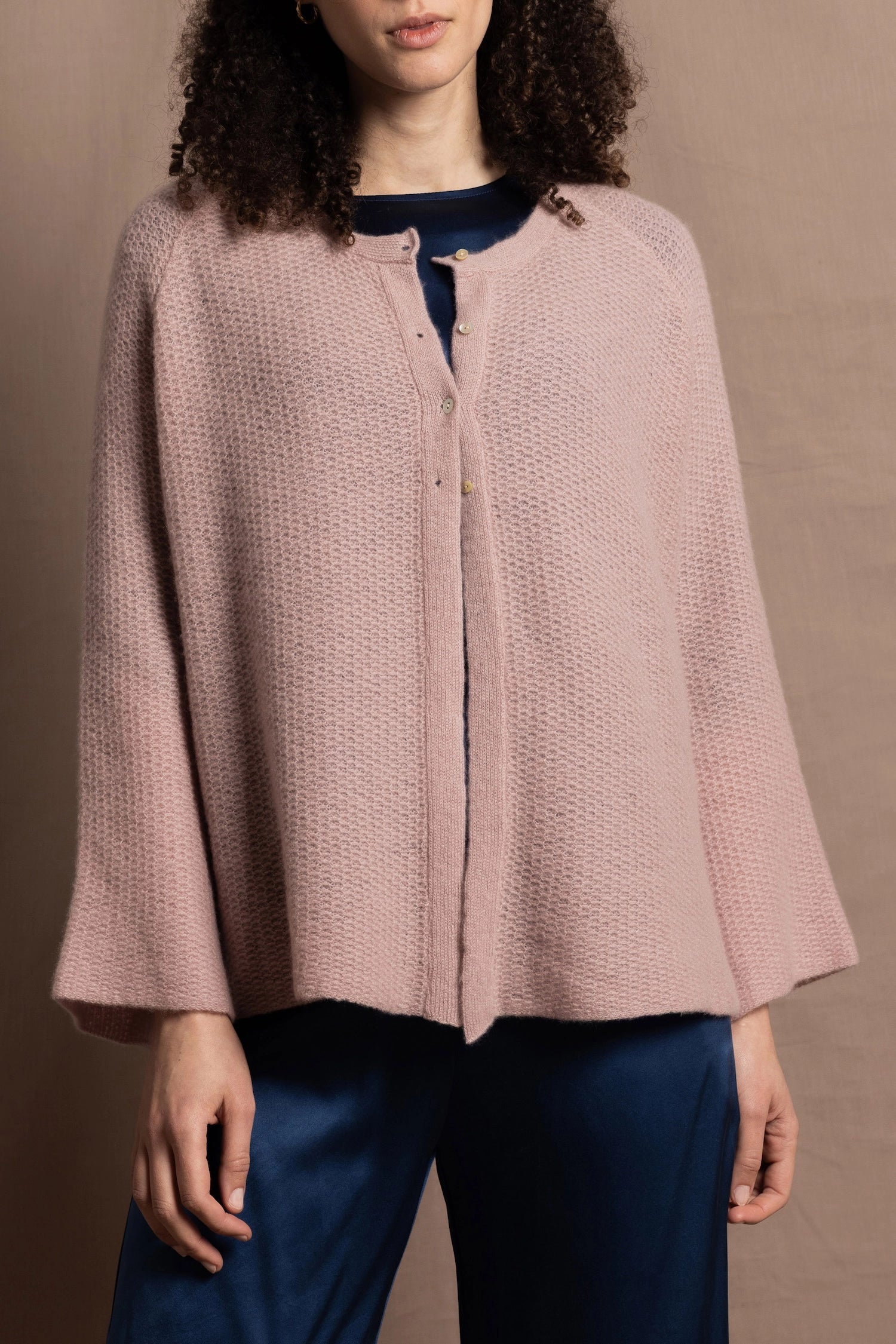 a 100% cashmere button down swing cardigan with moss stitch texture in dusty pink paired with navy blue silk top and trousers