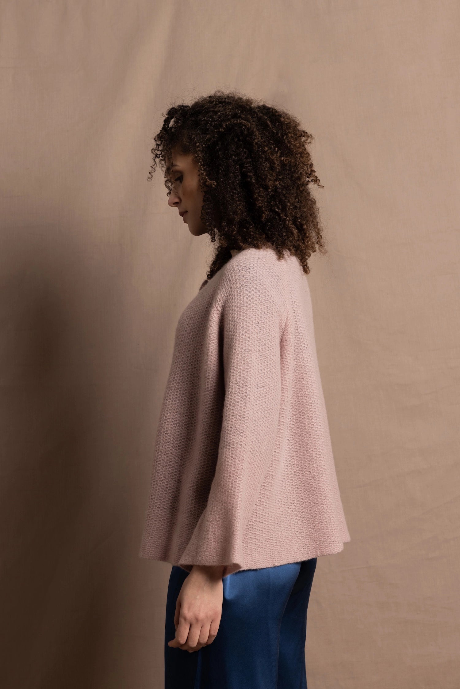 a 100% cashmere button down swing cardigan with moss stitch texture in dusty pink paired with navy blue silk top and trousers