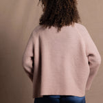 a 100% cashmere button down swing cardigan with moss stitch texture in dusty pink paired with navy blue silk top and trousers