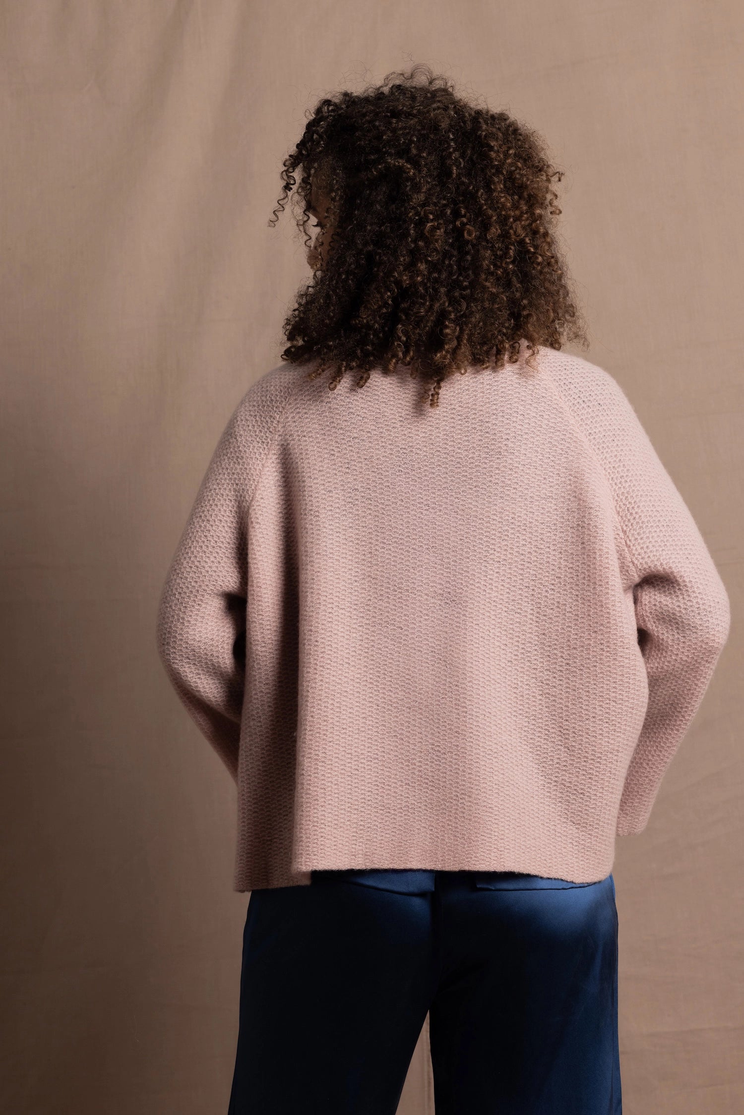 a 100% cashmere button down swing cardigan with moss stitch texture in dusty pink paired with navy blue silk top and trousers