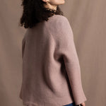 a 100% cashmere button down swing cardigan with moss stitch texture in dusty pink paired with navy blue silk top and trousers