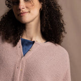 A close up shot of 100% cashmere button down swing cardigan with moss stitch texture in dusty pink