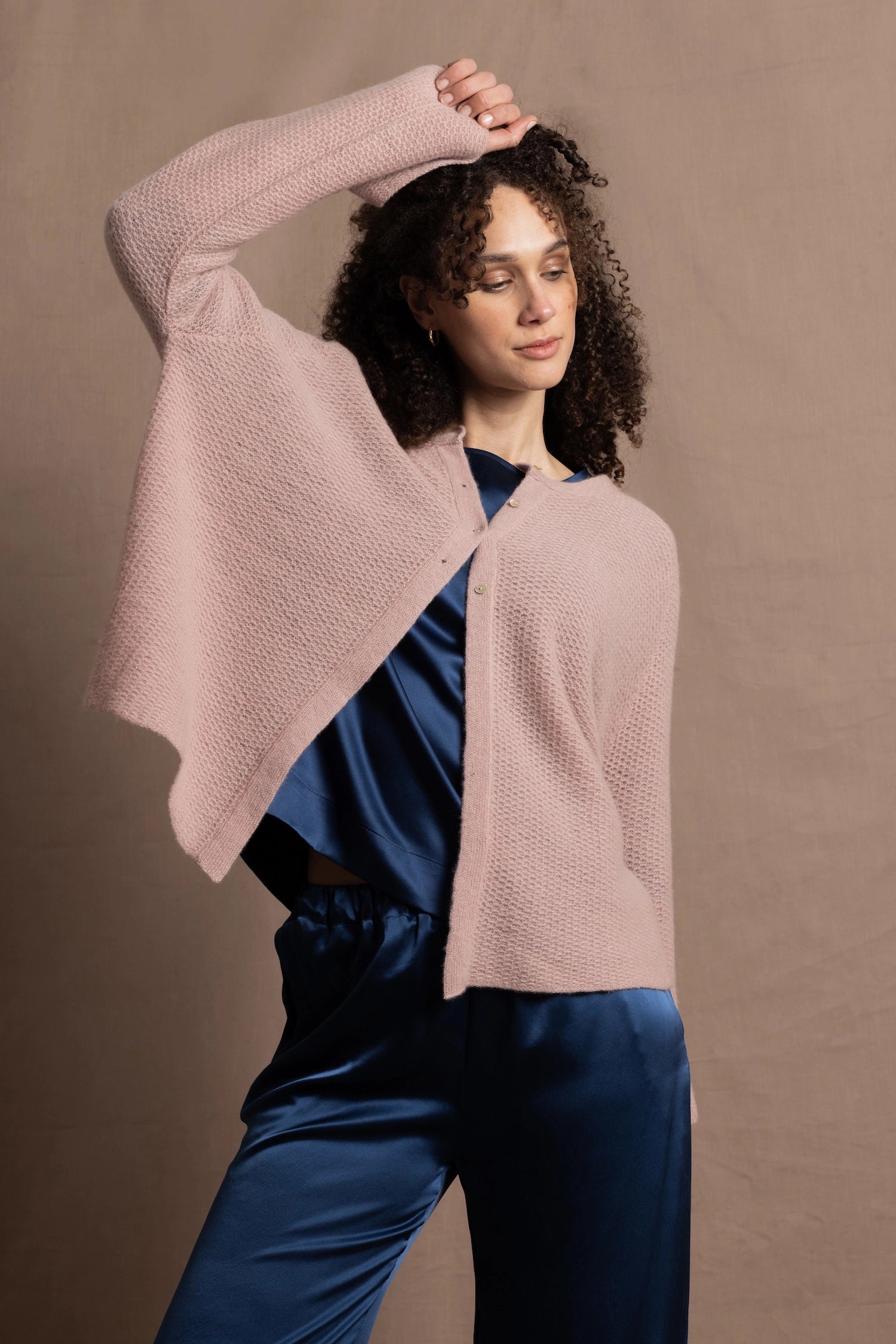 a 100% cashmere button down swing cardigan with moss stitch texture in dusty pink paired with navy blue silk top and trousers