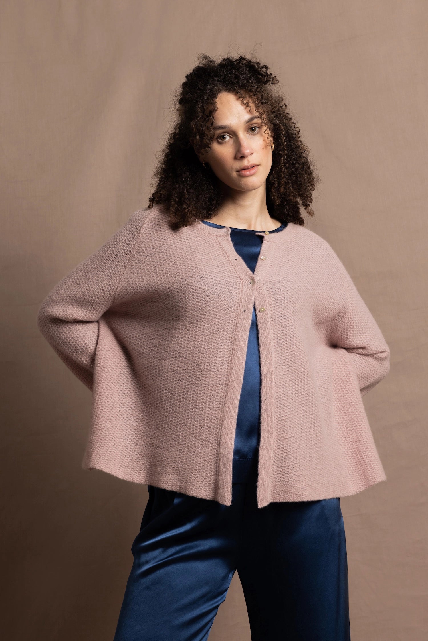 a 100% cashmere button down swing cardigan with moss stitch texture in dusty pink paired with navy blue silk top and trousers
