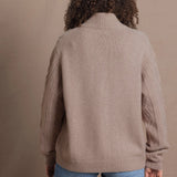a woman wears a taupe coloured cashmere aran cardigan sweater with horn buttons