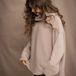 a woman wears an oversized 100% cashmere sweater in beige by Irish brand Madigan Cashmere