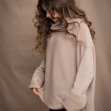 a woman wears an oversized 100% cashmere sweater in beige by Irish brand Madigan Cashmere