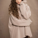 a woman wears an oversized 100% cashmere sweater in beige by Irish brand Madigan Cashmere