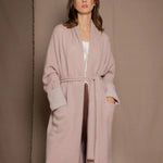 A woman wears a pure 100% cashmere dressing gown or robe in dusty pink