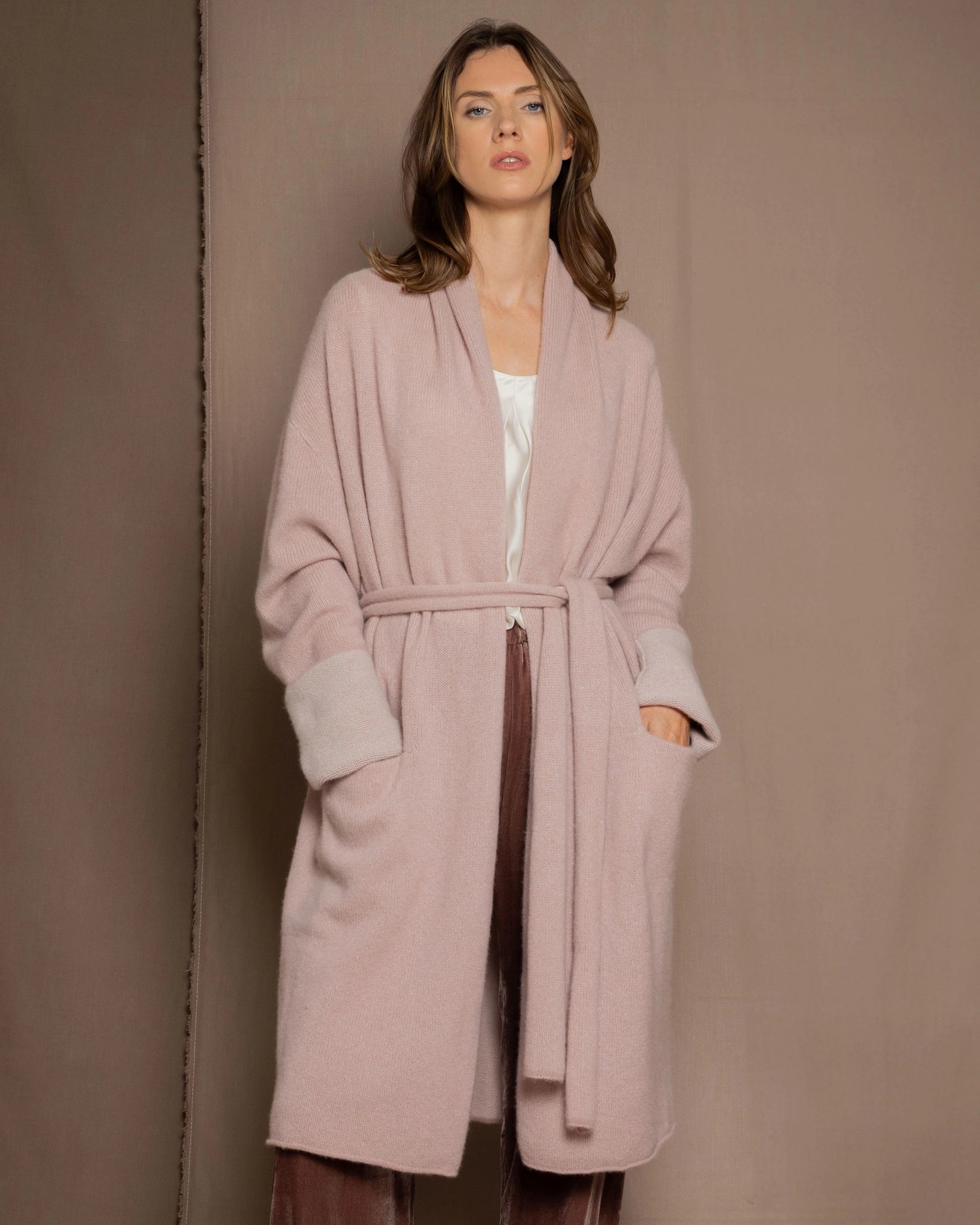 A woman wears a pure 100% cashmere dressing gown or robe in dusty pink