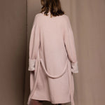 A woman wears a pure 100% cashmere dressing gown or robe in dusty pink