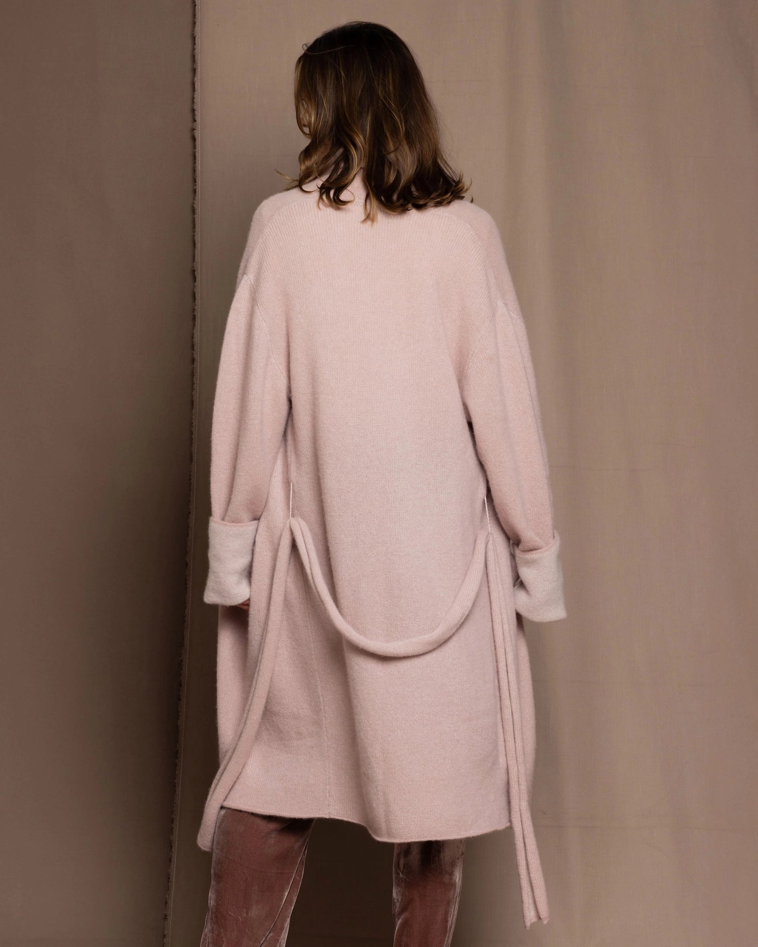 A woman wears a pure 100% cashmere dressing gown or robe in dusty pink