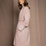 A woman wears a pure 100% cashmere dressing gown or robe in dusty pink