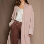 A woman wears a pure 100% cashmere dressing gown or robe in dusty pink