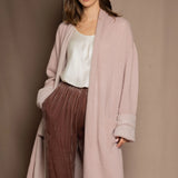 A woman wears a pure 100% cashmere dressing gown or robe in dusty pink
