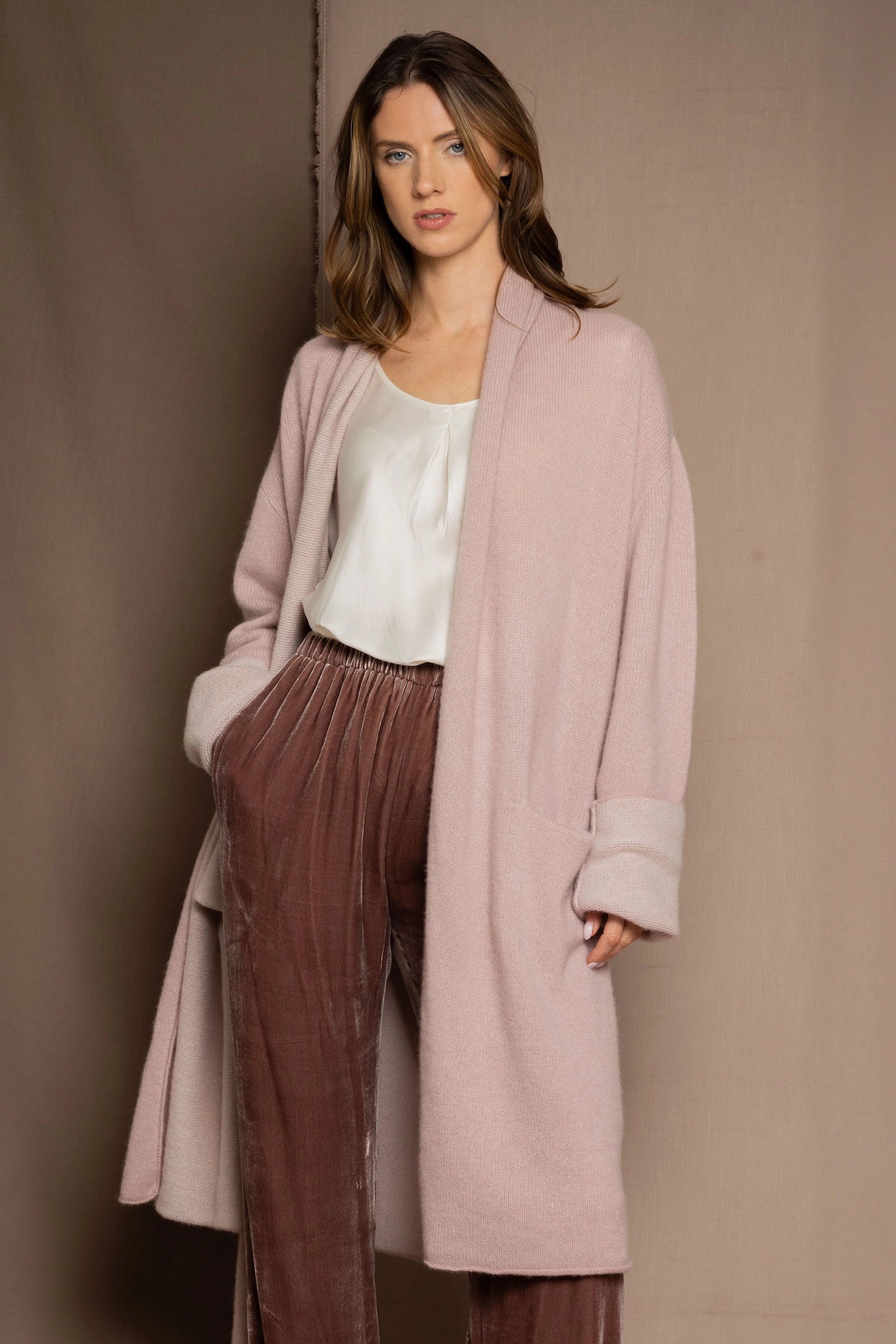 A woman wears a pure 100% cashmere dressing gown or robe in dusty pink