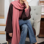 woman wearing a large cashmere travel wrap shawl in dusty pink rose 