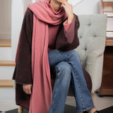 woman wearing a large cashmere travel wrap shawl in dusty pink rose 