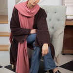 woman wearing a large cashmere travel wrap shawl in dusty pink rose 