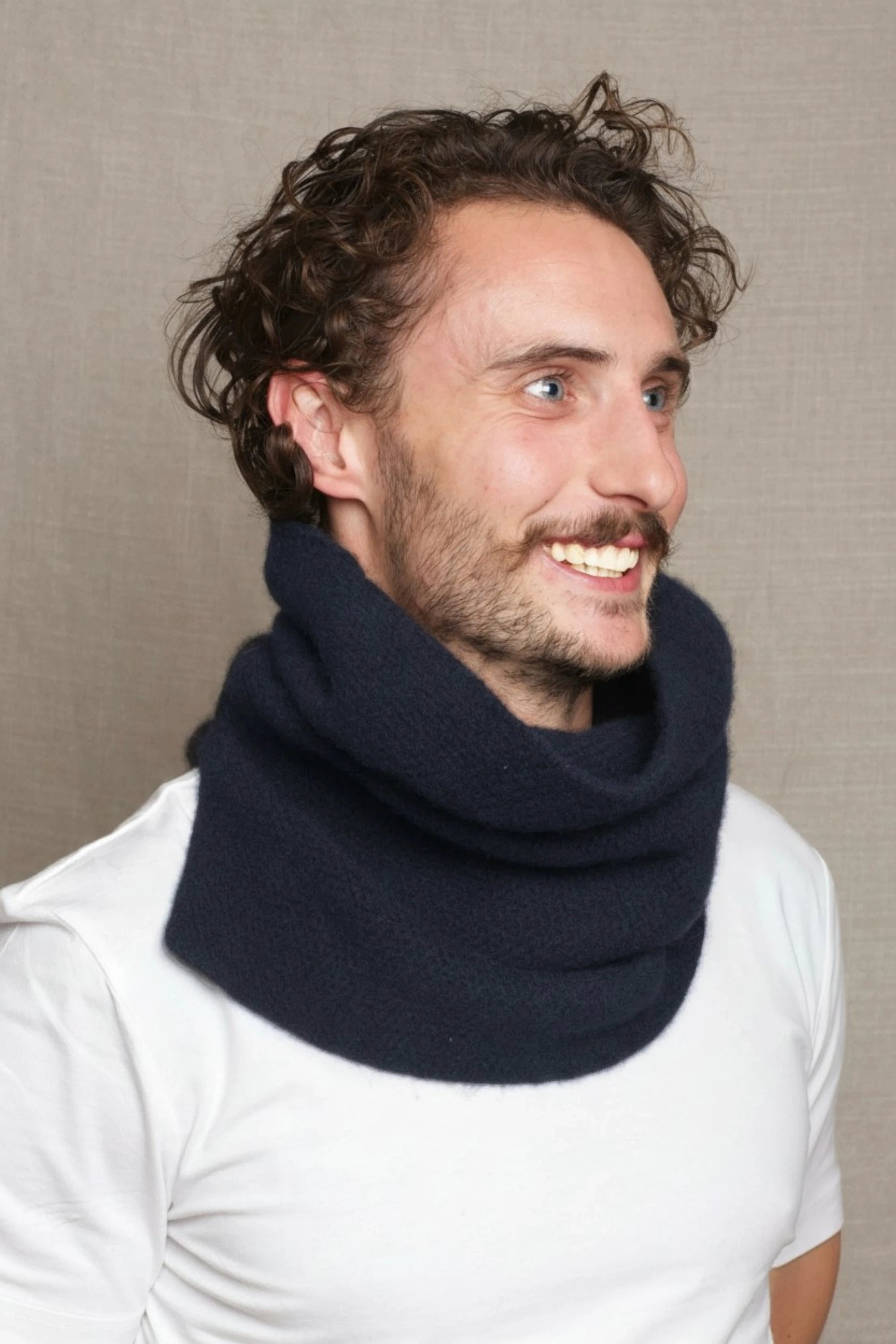 a man wears a thick cashmere snood neck gaiter with a textured moss stitch in a navy blue colour by Irish Cashmere brand Madigan Cashmere