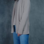 Lady wears beige coloured open cashmere cardigan over matching cashmere tee 