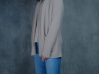 Lady wears beige coloured open cashmere cardigan over matching cashmere tee 