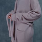 A woman wears a pure 100% cashmere dressing gown or robe in dusty pink