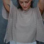 a woman wears a sheer cashmere lace summer tee over silk top and trousers 
