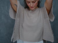 a woman wears a sheer cashmere lace summer tee over silk top and trousers 