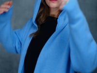 lady standing with 100% cashmere tee short sleeve sweater in black with blue cashmere coat over top