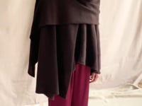 video of a woman wearing a large cashmere wrap shawl in dark brown eith matching cashmere beanie hat and burgundy silk trousers