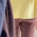 a video of a woman wearing a cashmere scarf in chocolate brown over a cashmere tee in yellow