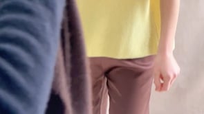 a video of a woman wearing a cashmere scarf in chocolate brown over a cashmere tee in yellow