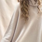 a video of a woman wearing an oversized 100% cashmere sweater in beige by Irish brand Madigan Cashmere