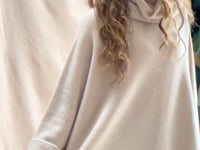 a video of a woman wearing an oversized 100% cashmere sweater in beige by Irish brand Madigan Cashmere