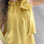 a video of a woman wearing a large cashmere scarf in pale yellow with matching cashmere beanie hat and cashmere tee sweater by Madigan Cashmere 