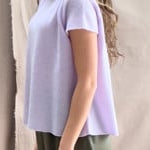 a video of a woman wearing a 100% pure cashmere tee sweater in light purple by Irish brand Madigan Cashmere and silk trousers in dark green