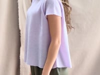 a video of a woman wearing a 100% pure cashmere tee sweater in light purple by Irish brand Madigan Cashmere and silk trousers in dark green