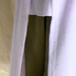 a video of a woman wearing a light purple cashmere cardigan coat over a matching cashmere tee sweater and green silk trousers by Irish brand Madigan