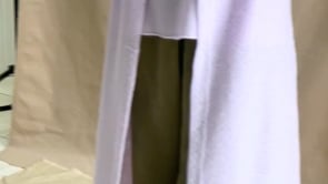 a video of a woman wearing a light purple cashmere cardigan coat over a matching cashmere tee sweater and green silk trousers by Irish brand Madigan