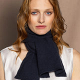 a woman wears a dark blue grey cashmere scarf 