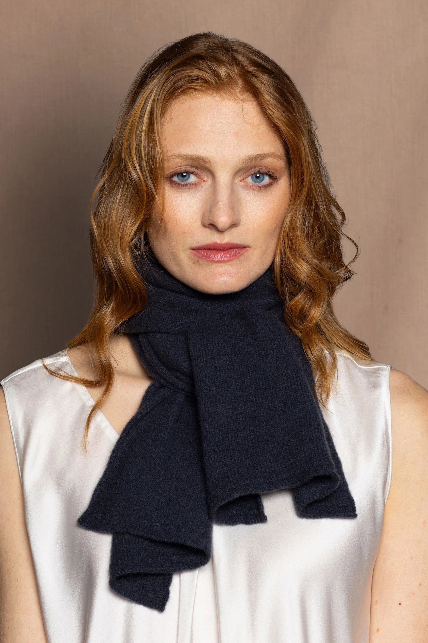 a woman wears a dark blue grey cashmere scarf 