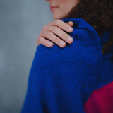 a woman wears a lace cashmere wrap shawl in indigo blue