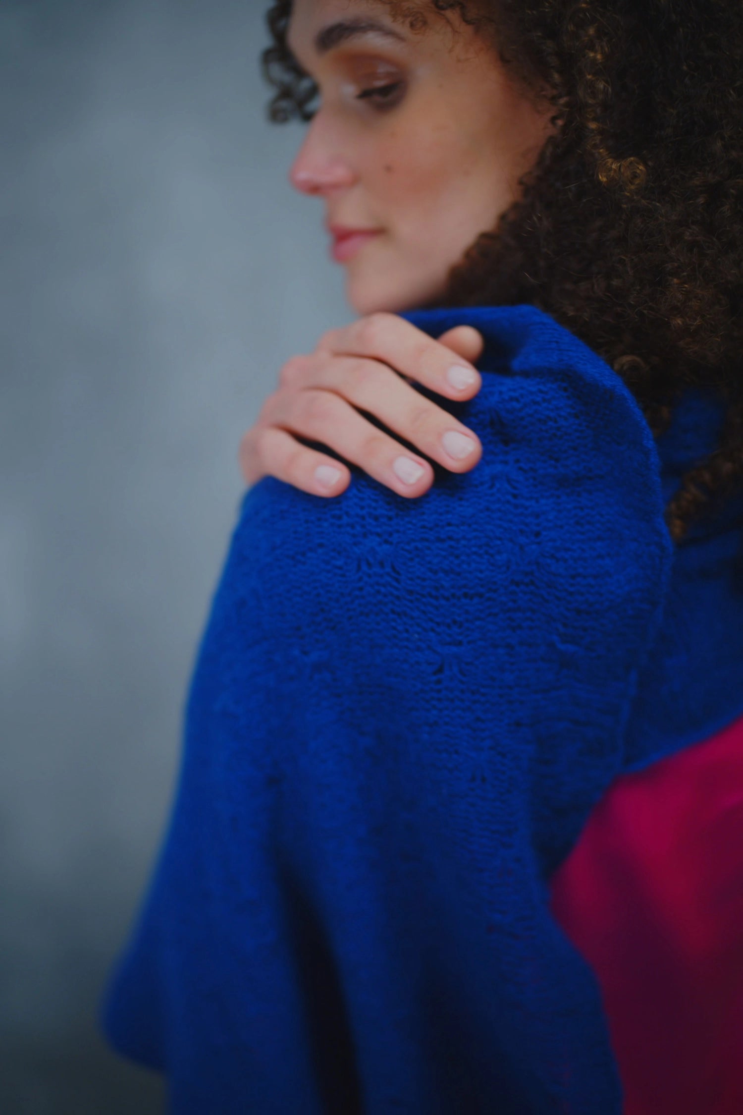 a woman wears a lace cashmere wrap shawl in indigo blue